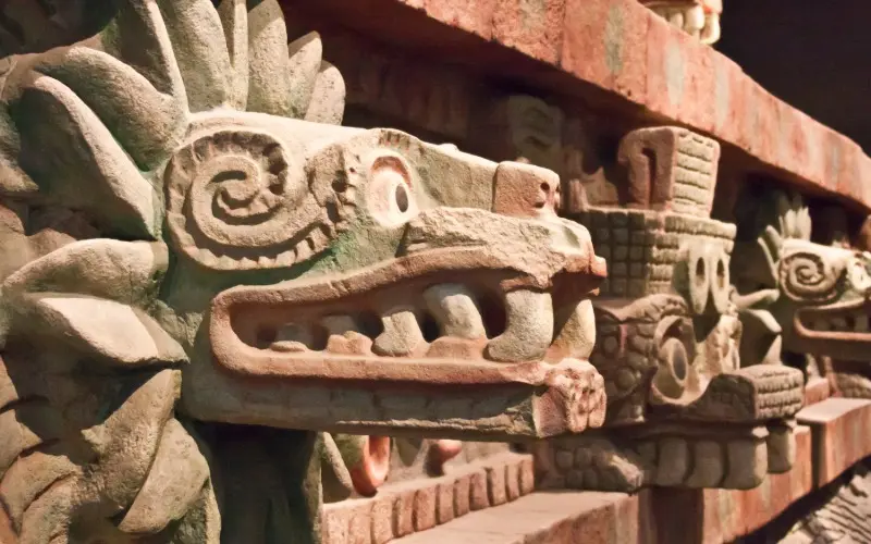 Escultura prehispánica asociada a Quetzalcóatl en zona arqueológica mesoamericana